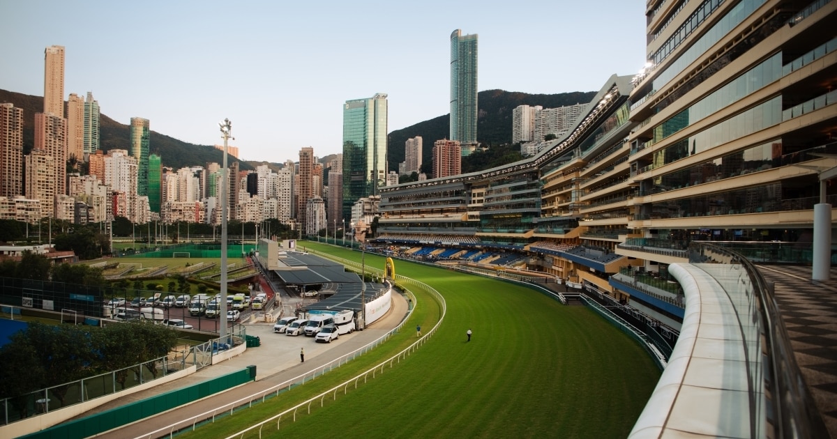 Tracks of Happy Valley Racecourse surrounded by cityscape.